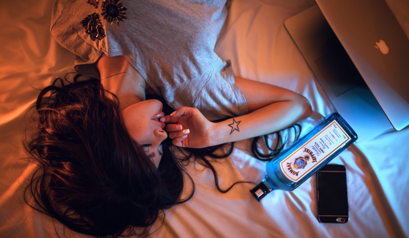 Girl on a bed with a bottle