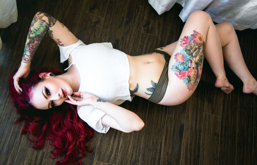 Red -haired girl with a tattoo on her foot