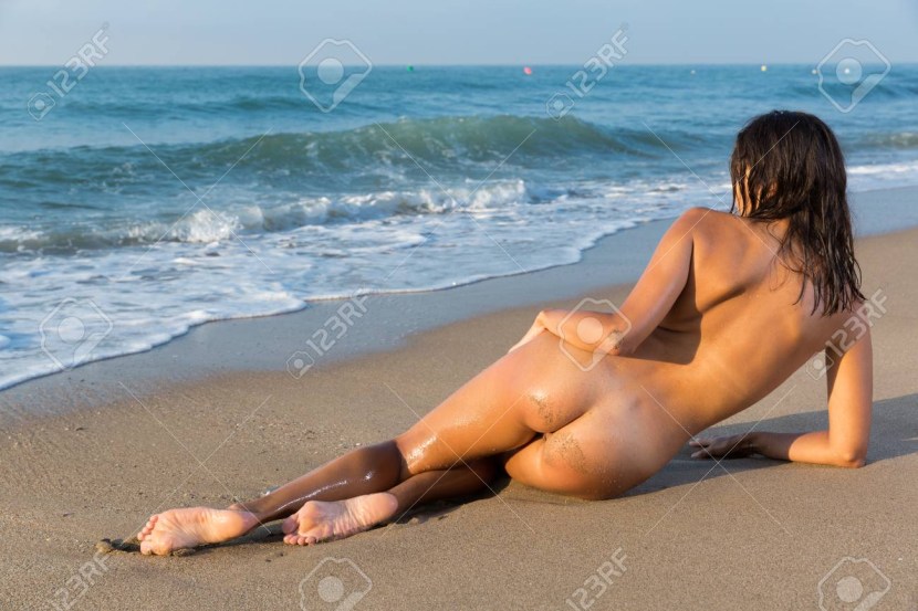 Naked Girl On Beach Laying on Her Stomach Feet Up
