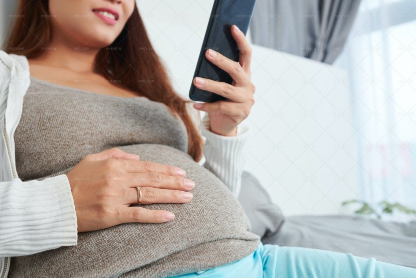 Pregnant woman sits on a computer