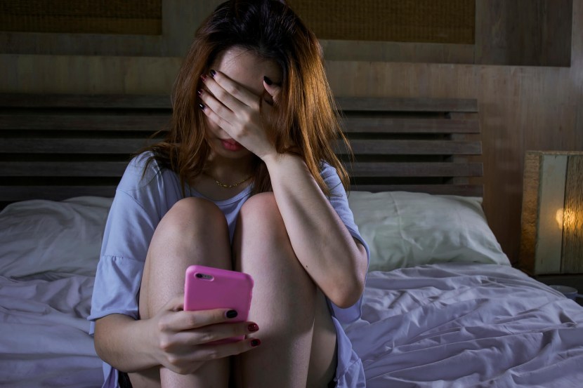Girl with a phone in her hands on the bed