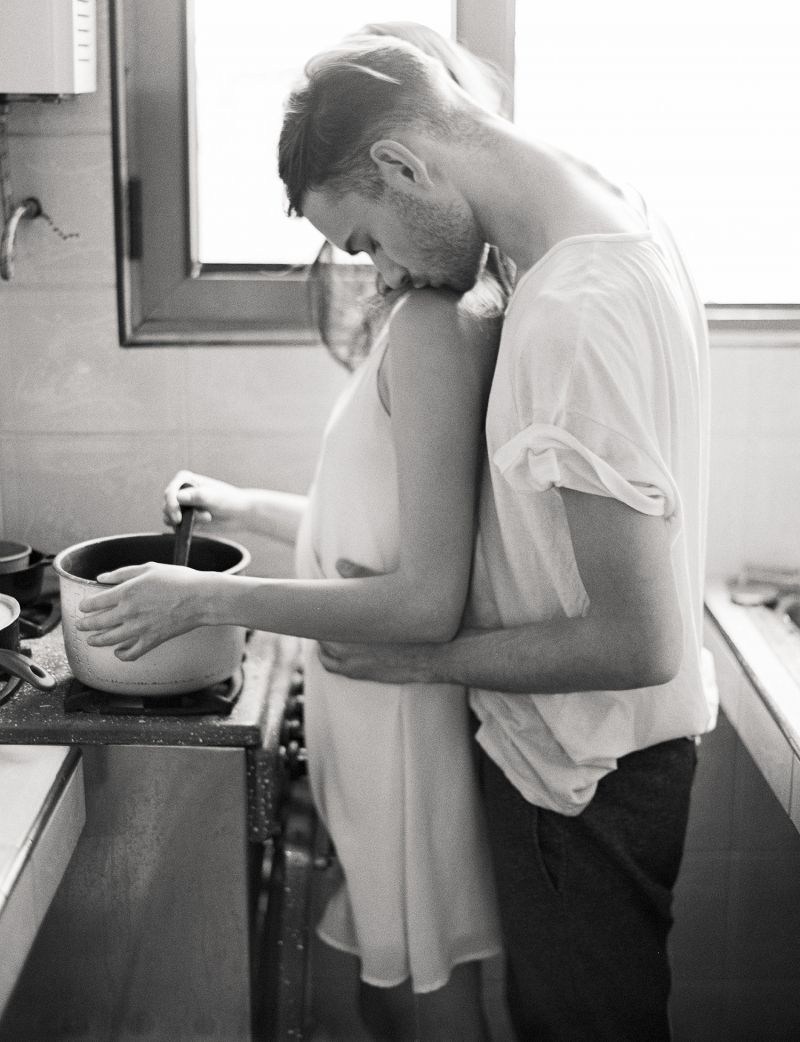 The guy hugs in the kitchen