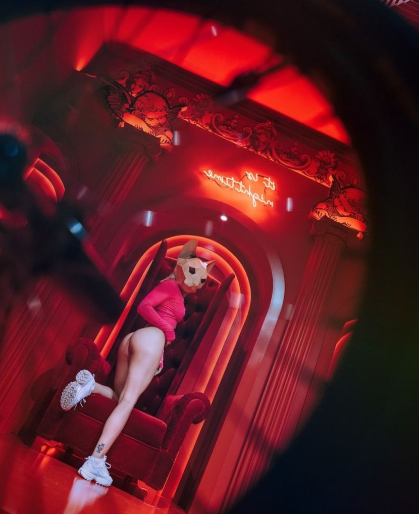 Poses for a photo shoot in a short dress