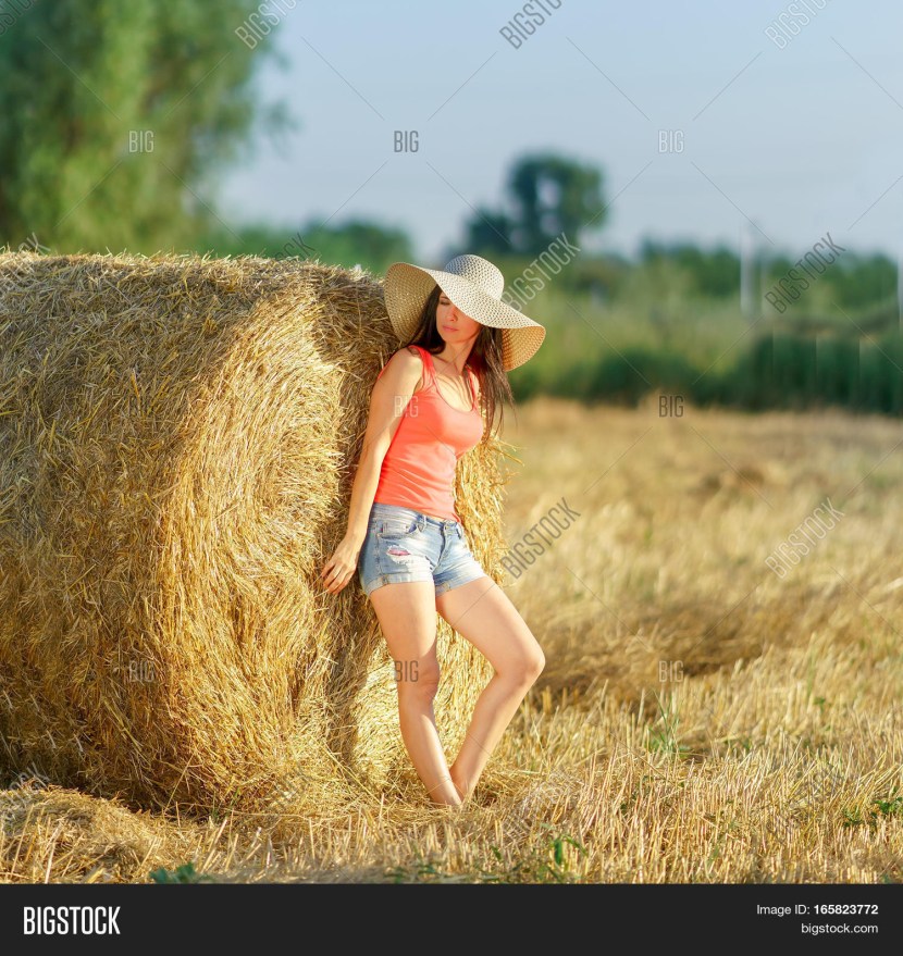 Photoshoot in a straw hat and a hay of hay
