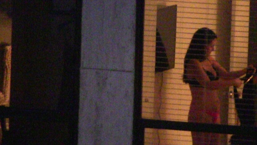 Naked women in the windows of houses