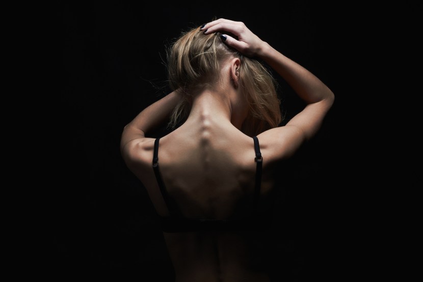 Naked model from the back on a black background
