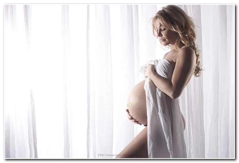 Photo of a pregnant woman's tummy against a window background