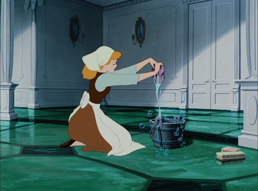 The woman sweeps the floor with a broom