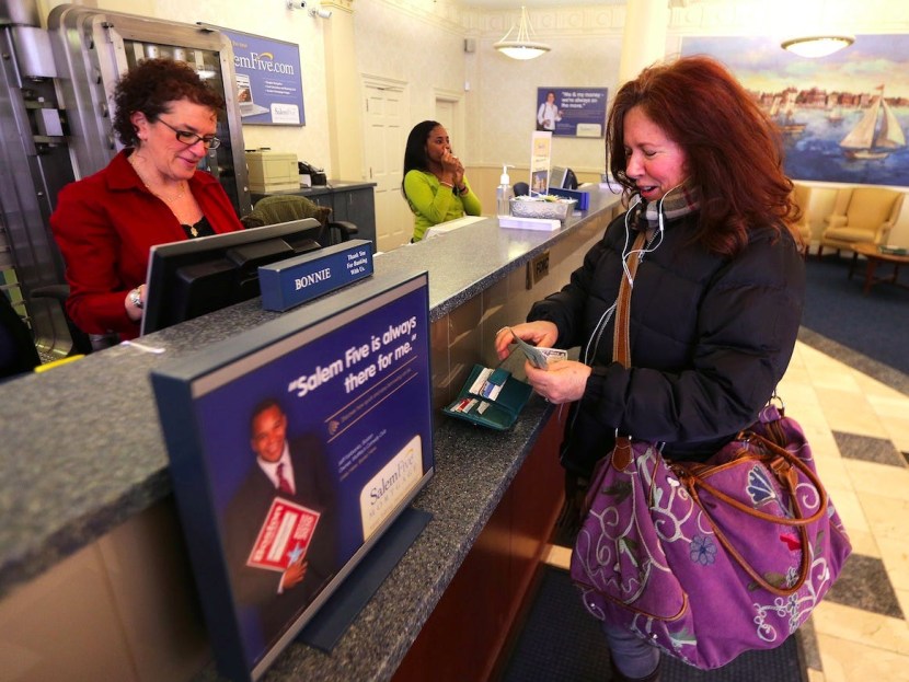 A person puts money in a bank