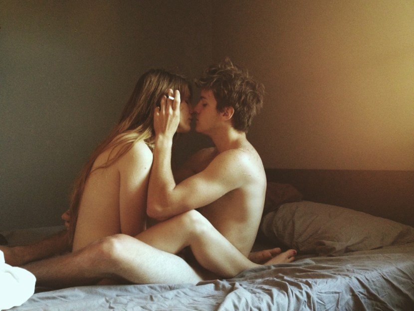 Girl sits on a guy in bed